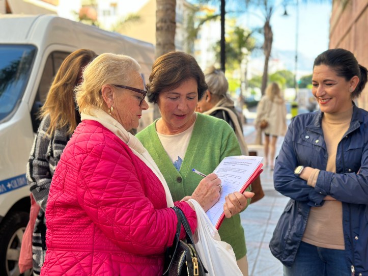 Carmen Segura atiende a una ciudadana que quiere firmar la petición
